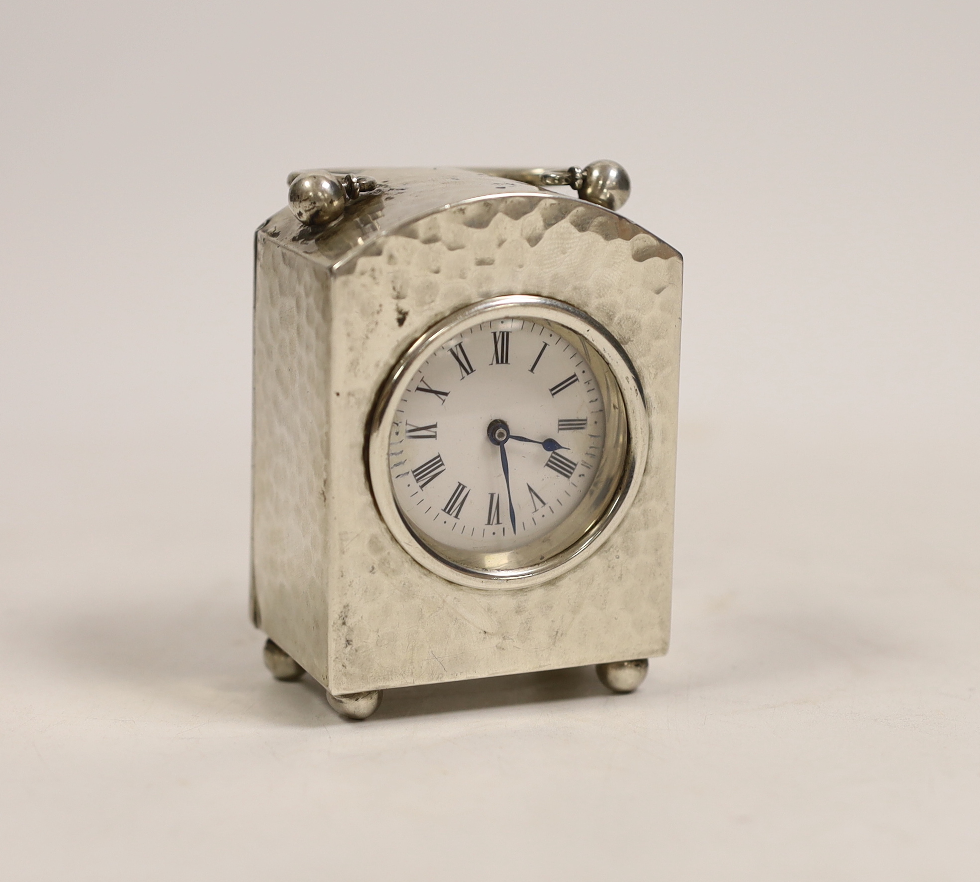 An Edwardian planished silver cased carriage timepiece, W & G Neal, London, 1906, on ball feet, height 8.5cm.